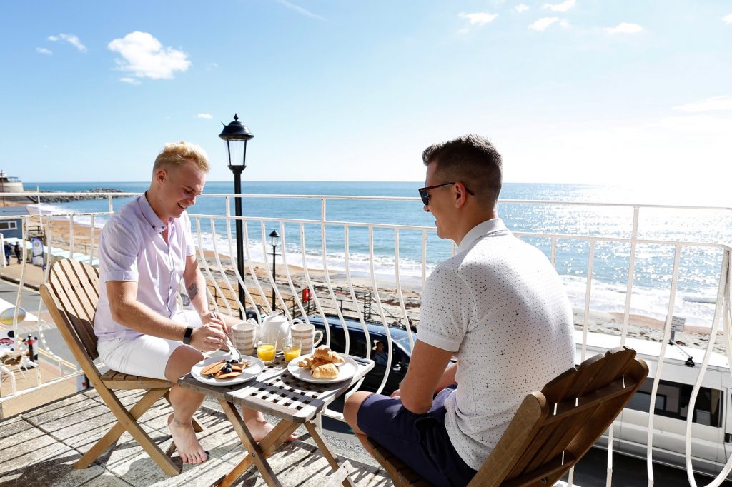 Couple enjoying breakfast on the balcony area with views of Ventnor seafront