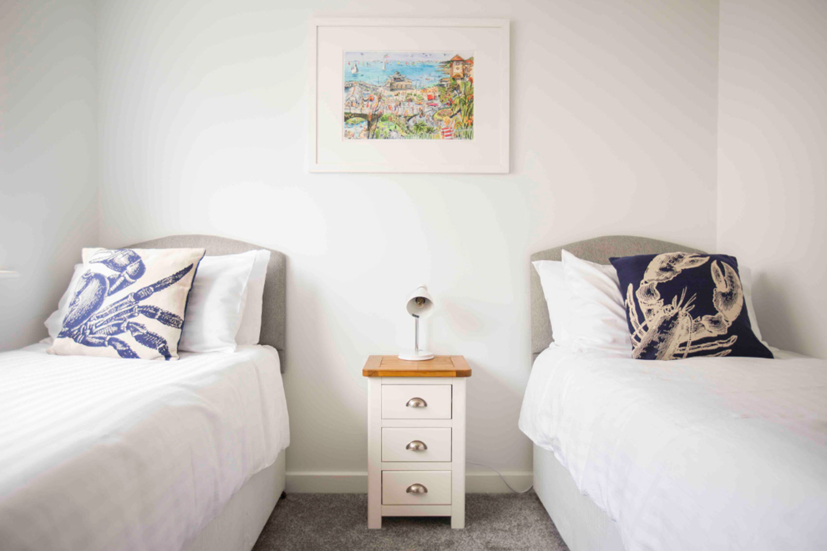 Beach Haven twin room with singular bedside cabinet with bedside lamp.