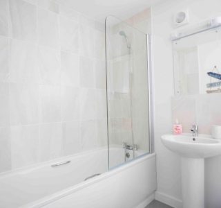 Beach Havens bathroom with bath/shower. Mirror above wash basin