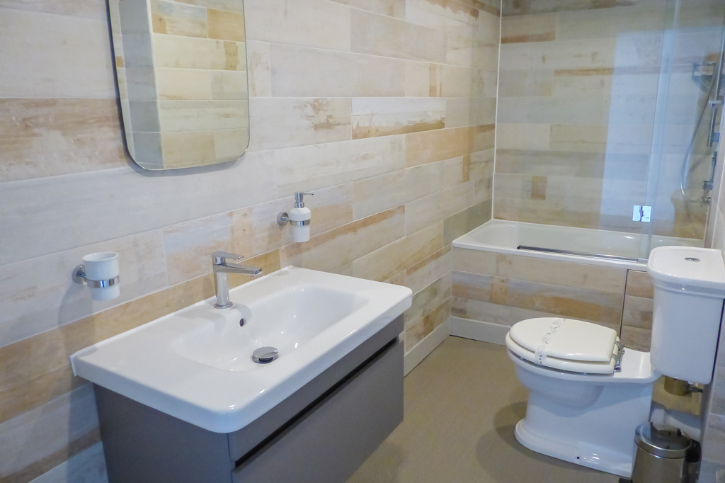 Master Bathroom, Toilet, Bath with overhead shower. Large wash basin with singular mixer tap. Mirror above wash basin.