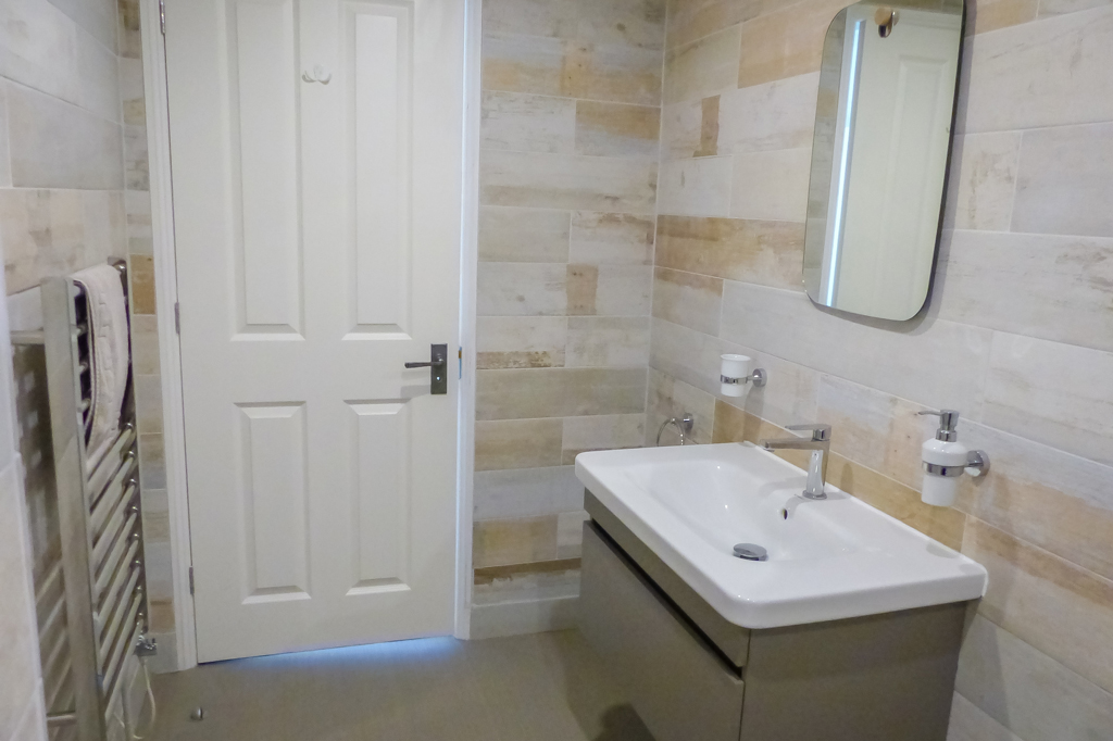 Master Bathroom. Wash basin with singular mixer tap and above mirror, pictured right. Heated towel rail shown left