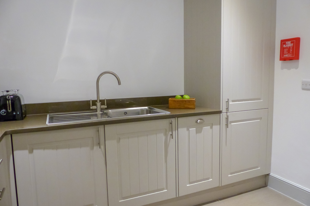 Kitchen area, sink with singular mixer tap. Fridge is built in on the left side to inkeep with the decor.