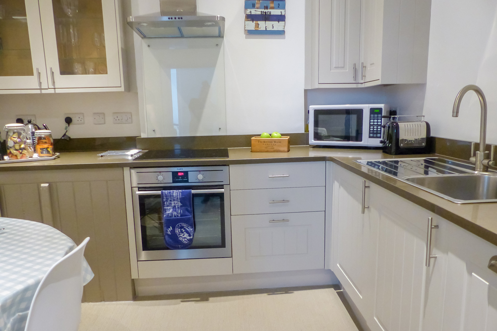 Paskins kitchen area, fitted with electric oven and hob, dishwasher, washing machine, microwave and toaster. Kettle and tea/coffee making facilities are pictured left.
